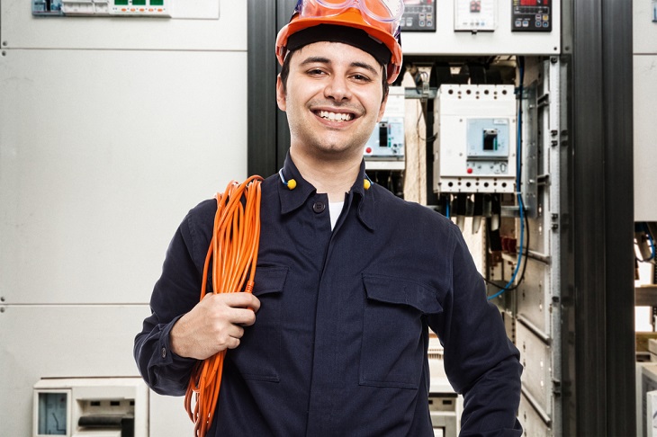 Qualified Electrician smiling and holding cable