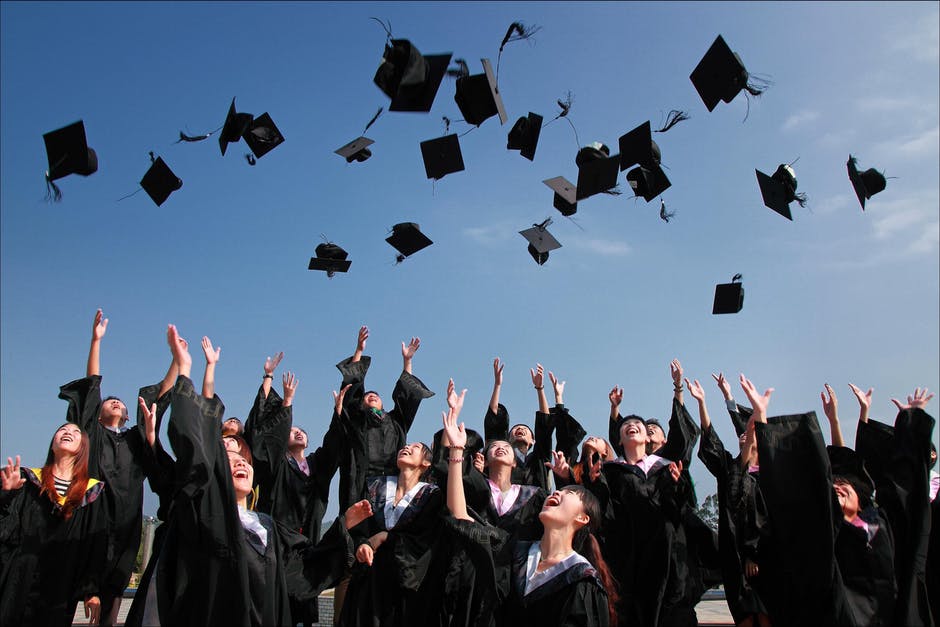graduate throwing hats in air