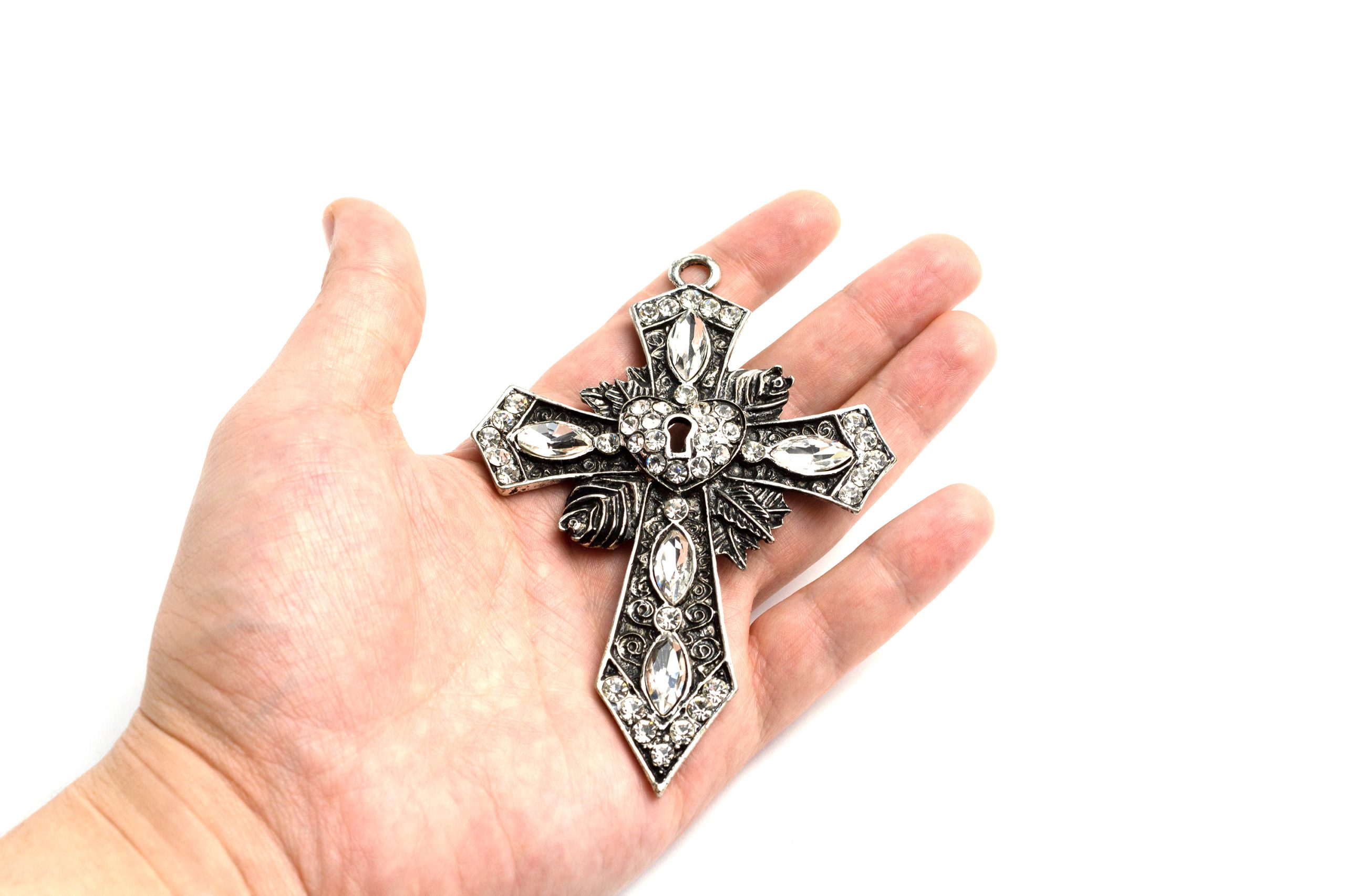 Big cross with rhinestones in hand on a white background isolate