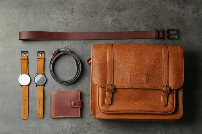 Flat lay composition with leather bag and accessories on grey st